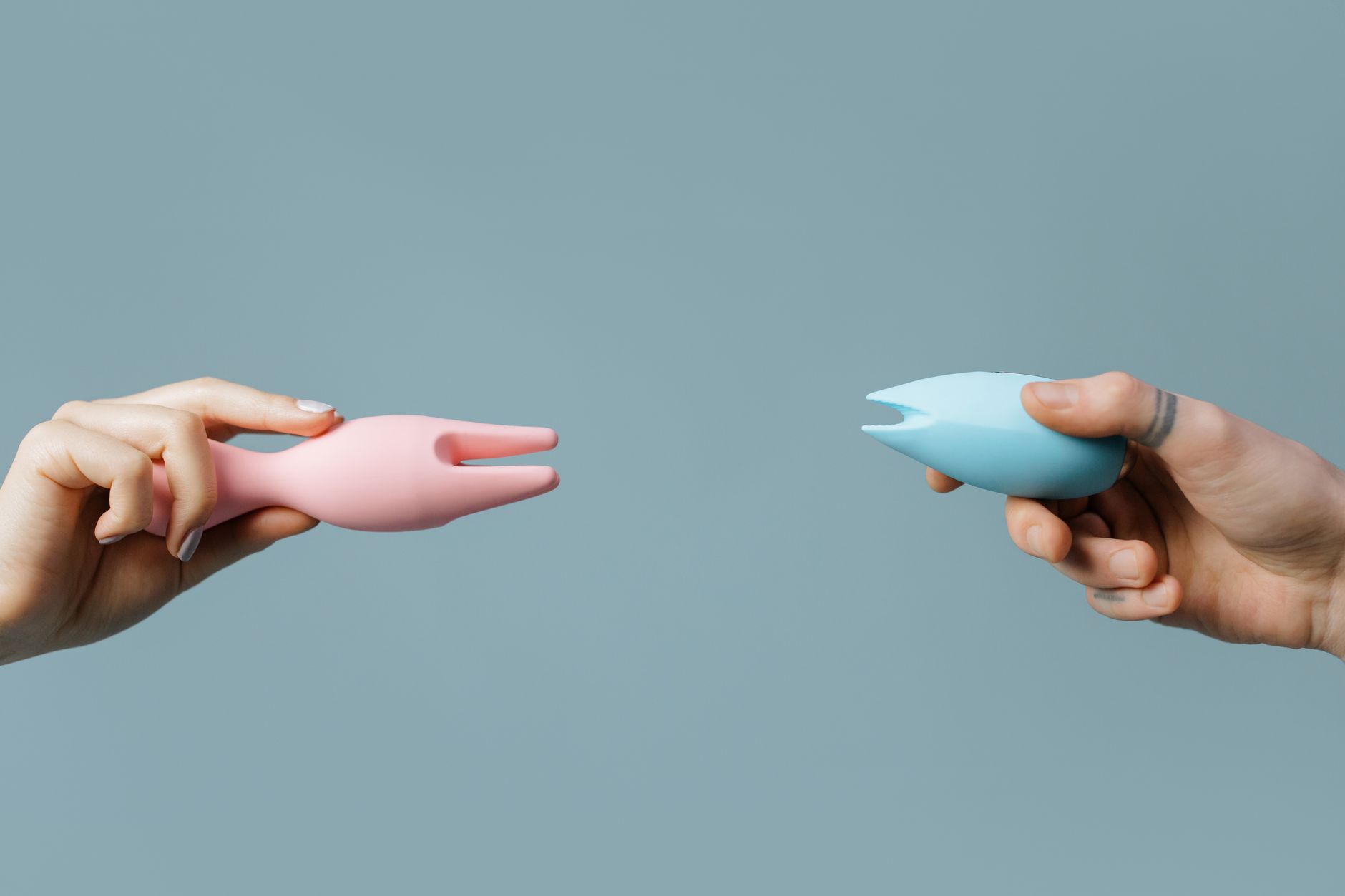 Hands holding a sleek blue vibrator against a purple background, representing reconnection with body and pleasure.