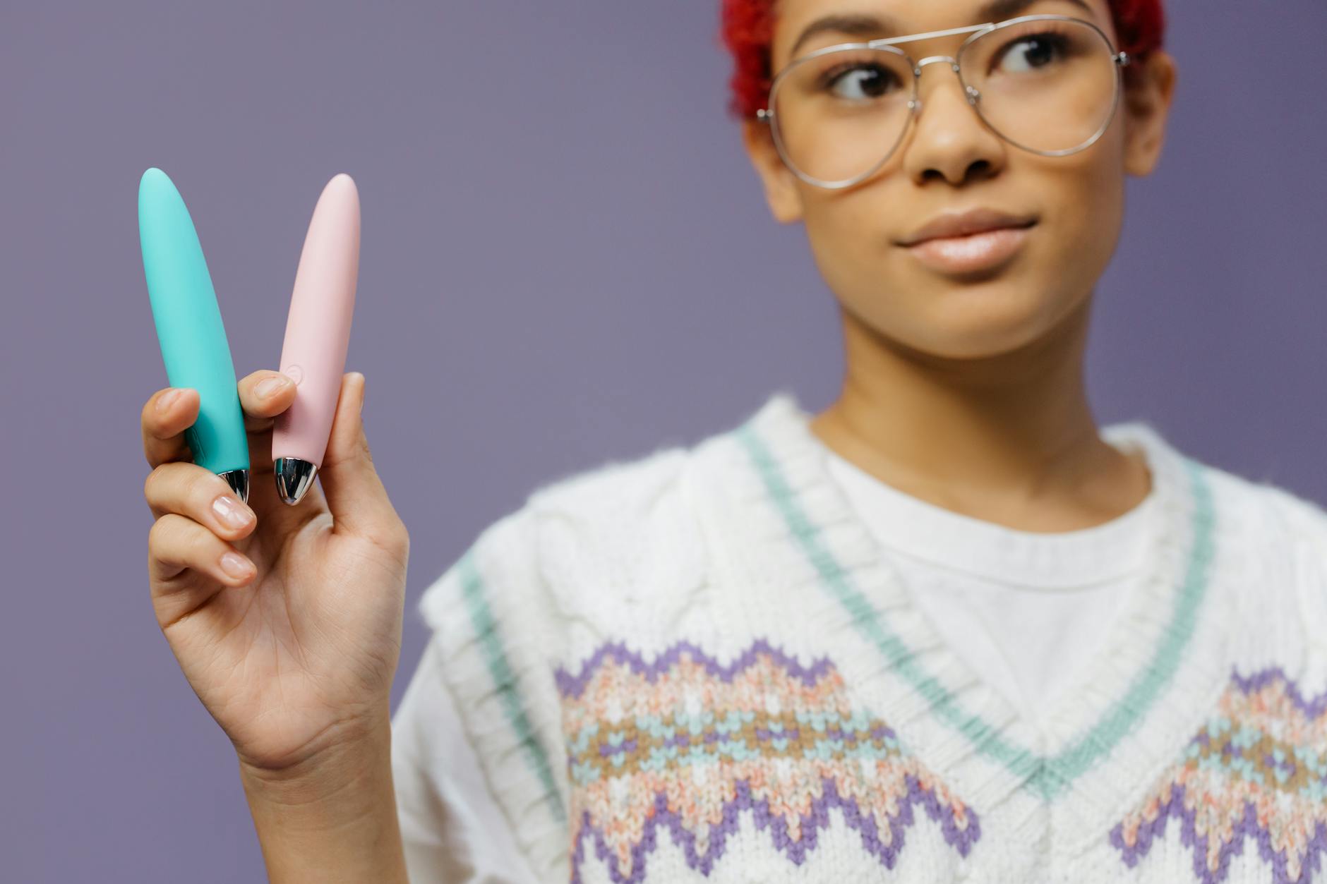 Woman holding a lemon clitoral vibrator with art books and plants nearby, representing the intersection of intimacy and self-knowledge