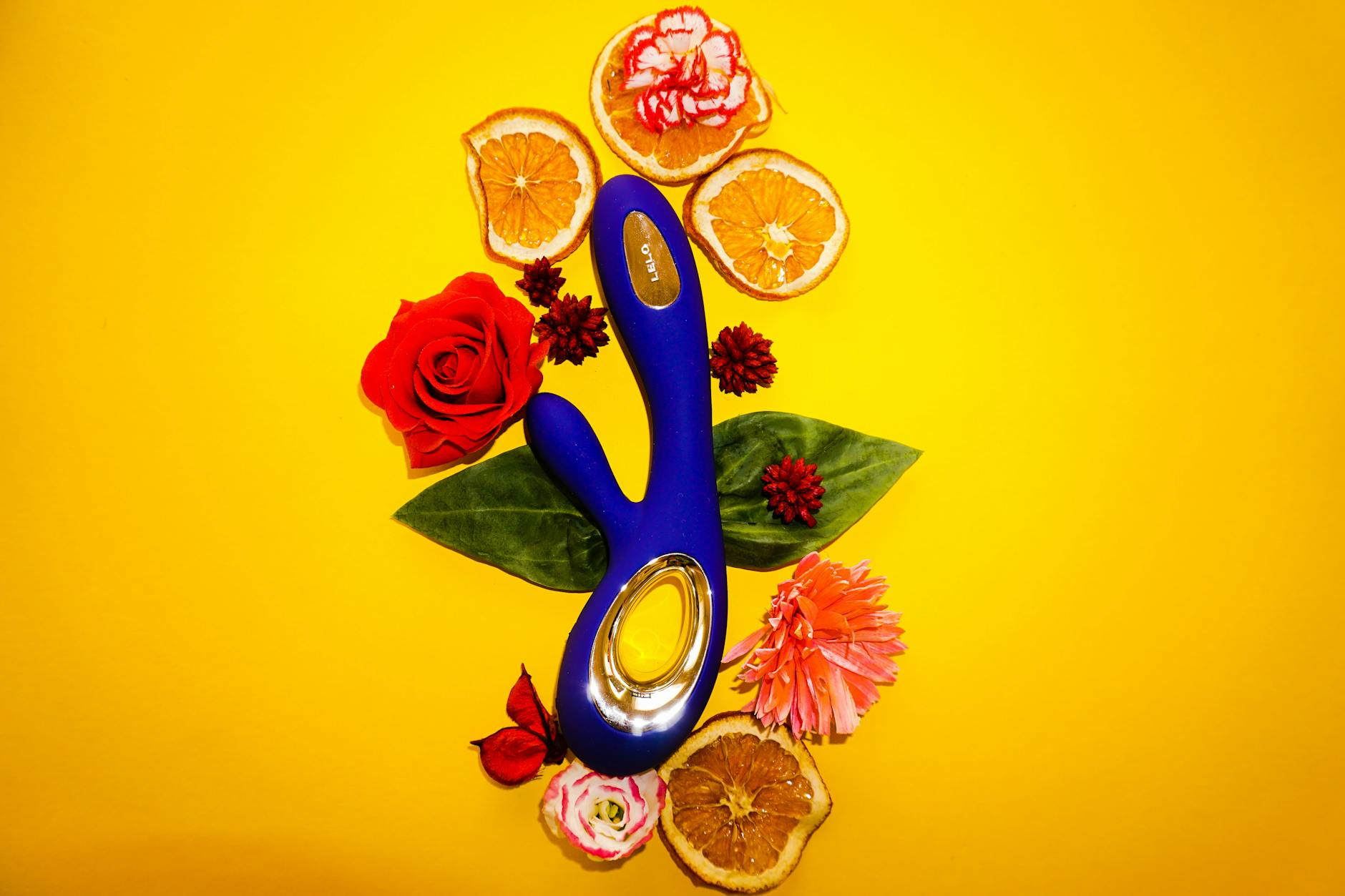 A lemon-colored vibrator surrounded by fresh lemons and orange slices on a bright yellow background, symbolizing renewal and gentle pleasure.